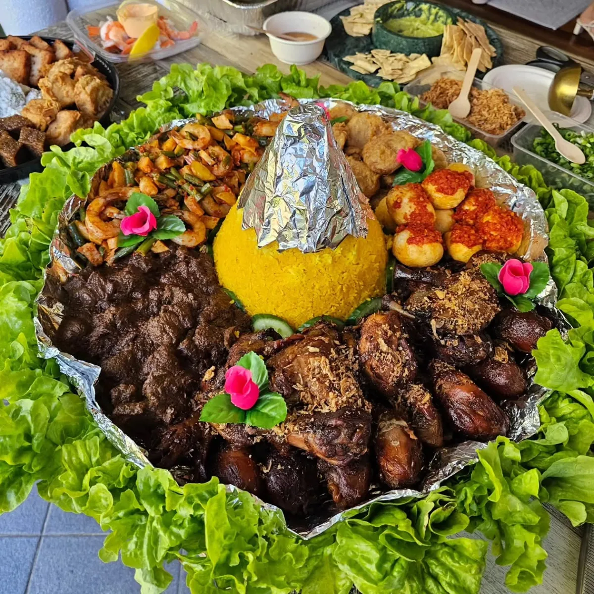 Yellow-rice tumpeng surrounded by Indonesian side dishes